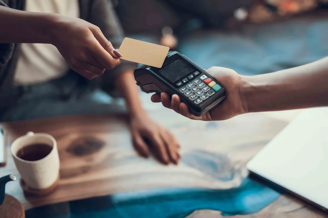 Customer making a contactless credit card payment at checkout